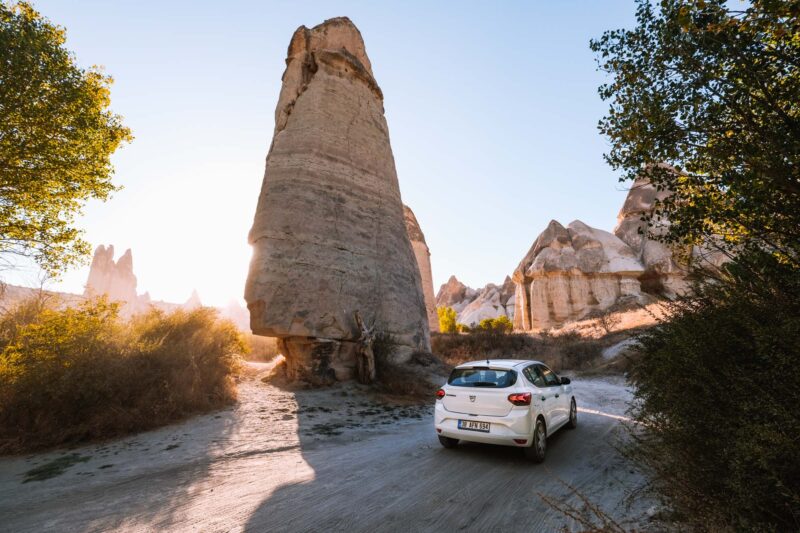 Witte auto rijdt door love valley in Cappadocië